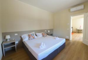 a bedroom with a large white bed and a table at Affittacamere Marilù in Paratico