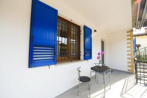 a patio with blue windows and two stools at Affittacamere Marilù in Paratico