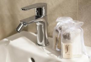 a bathroom sink with a faucet and a bottle of soap at Affittacamere Marilù in Paratico +76 photos
