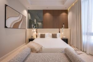 a bedroom with a large white bed and a window at Rozn Place Apartments in Jeddah