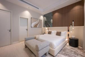 a bedroom with a white bed and a chair at Rozn Place Apartments in Jeddah