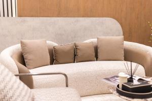 a living room with a white couch with pillows at Rozn Place Apartments in Jeddah +137 photos