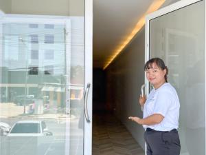 a woman standing in front of a glass door at Abundant Eco Hostel in Laguna Phuket