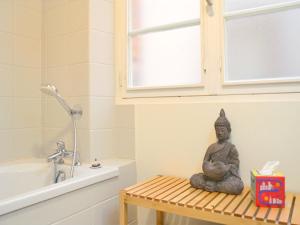 a statue of a buddha sitting on a bench in a bathroom at Le Chaud Vin - Centre historique Albi - Zone Unesco - Animaux acceptés in Albi +27 photos