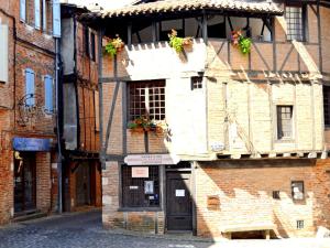 an old brick building with flowers on a balcony at Le Chaud Vin - Centre historique Albi - Zone Unesco - Animaux acceptés in Albi