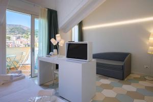 a living room with a tv and a couch at Hotel Melograno in Spotorno