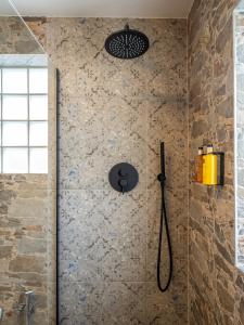 a shower in a bathroom with a stone wall at Cjase Friûl in Cividale del Friuli +30 photos