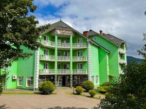 a large green building with a white balcony at Квітка Закарпаття in Polyana