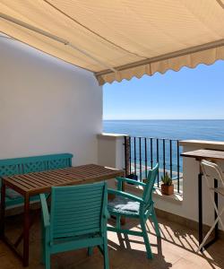 a patio with a table and chairs and the ocean at Ático dúplex - 1ª Linea playa in Adra