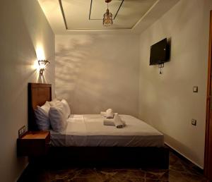 a bedroom with a bed with a tv on the wall at Casa Si Ahmed in Chefchaouen +9 photos