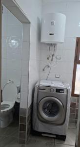 a bathroom with a washing machine and a toilet at Casa Si Ahmed in Chefchaouen