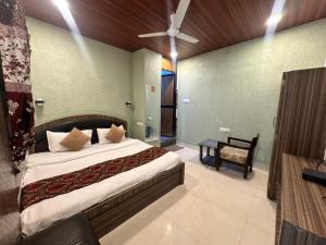 a bedroom with a large bed with a ceiling fan at Hotel Green Valley in Raipur