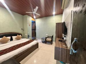 a bedroom with a bed and a flat screen tv at Hotel Green Valley in Raipur