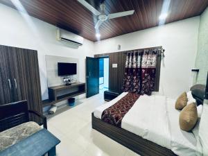 a bedroom with a bed and a tv and a couch at Hotel Green Valley in Raipur