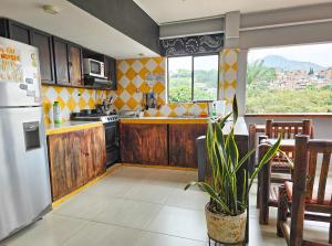 a kitchen with a refrigerator and a table at Maisant Hostel Cali, Street View, Good Food & Local Culture in Cali