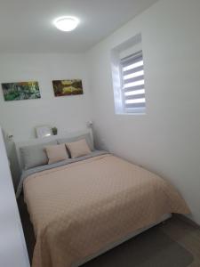 a bedroom with a bed in a white room at Studio apartment Cascada in Plitvička Jezera