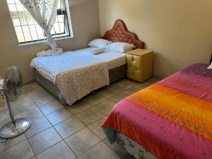 a bedroom with two beds and a window at Sun & Night in Empangeni