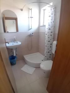 ein weißes Badezimmer mit Waschbecken und Toilette in der Unterkunft Sobe Soldo in Međugorje