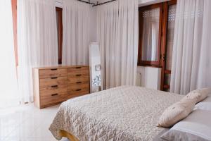 a bedroom with a bed and a wooden dresser at Appartamento Melo Grano in Tuoro sul Trasimeno