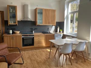 a kitchen with wooden cabinets and a table and chairs at Alte Gärtnerei in Blankenburg