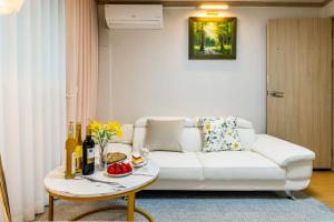 a living room with a white couch and a table at 홍대 골든스테이 in Seoul