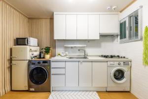 a kitchen with a washing machine and a washer at 홍대 골든스테이 in Seoul