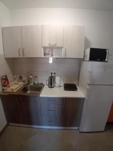 eine kleine Küche mit Spüle und Kühlschrank in der Unterkunft Sobe Soldo in Međugorje
