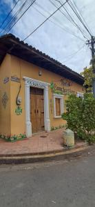 a yellow building with a door on a street at Hostal Casa Las Flores in Masaya +20 photos