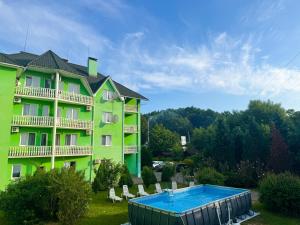 a hotel with a swimming pool in front of a building at Квітка Закарпаття in Polyana