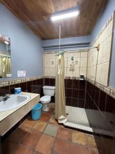 a bathroom with a toilet and a sink and a shower at Rm Dorm in San Quintín