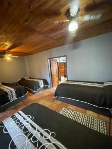 a room with two beds and a ceiling at Rm Dorm in San Quintín