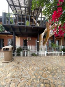 a building with a white fence in front of a building at Rm Dorm in San Quintín