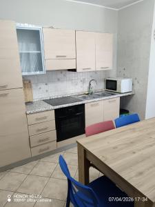 a kitchen with white cabinets and a table with chairs at Serena House in Robella