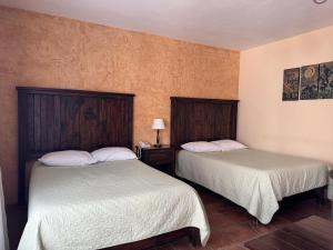 two beds in a hotel room with two beds sidx sidx sidx at Cachito Mio hotel y temazcal in Cholula
