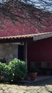 a red building with two potted plants in front of it at Casa de Margacide in Vila Nova de Cerveira