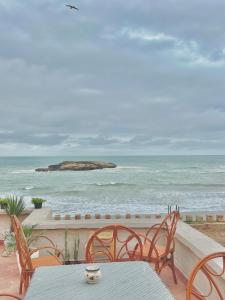 a table and chairs on a patio overlooking the ocean at Riad Sor in Essaouira