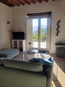a living room with a couch and a table and a sliding glass door at Villa Pavone in Coreglia Antelminelli