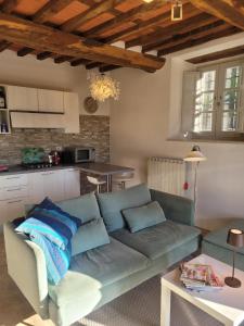 a living room with a blue couch and a kitchen at Villa Pavone in Coreglia Antelminelli