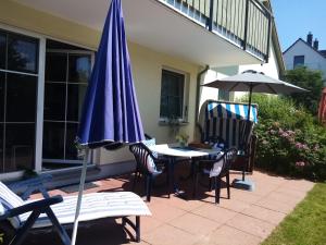 a patio with an umbrella and a table and chairs at Altes Wasserwerk App 10 in Wustrow