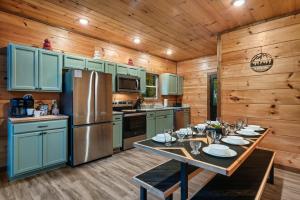 a kitchen with a table and a refrigerator at Dreamers Oasis in Sevierville
