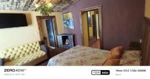 a bedroom with a bed and a couch and a tv at "De HugoS" hospedaje in Ibarra
