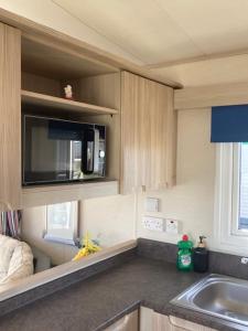 a kitchen with a sink and a microwave at The Blue Beachcomber in Chapel Saint Leonards