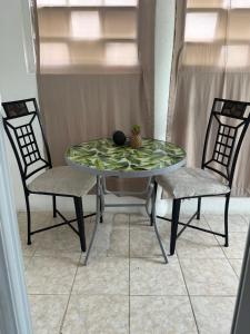 a glass table with two chairs and a bowl on top at Cerca de Aeropuerto , bleseed house in Monte Adentro +12 photos