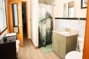 a bathroom with a sink and a toilet and a shower at Foothills Lodge & Cafe in Malone +24 photos