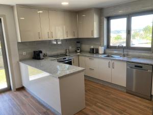 a kitchen with white cabinets and a counter top at Casa Alex in Arão