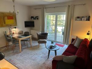 a living room with a red couch and a table at Die kleine Acht - direkt am Strand in Dierhagen