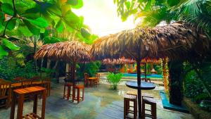 a restaurant with tables and chairs and umbrellas at Amazon City in Pucallpa