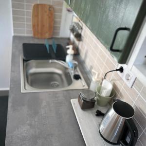 a kitchen counter with a sink and a coffee pot at Kisház in Kisoroszi