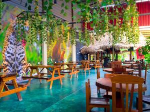 a restaurant with wooden tables and chairs and plants at Amazon City in Pucallpa