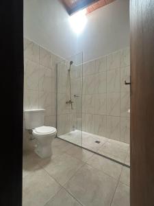 a bathroom with a toilet and a glass shower at Duplex NR in Nu Guazu +11 photos